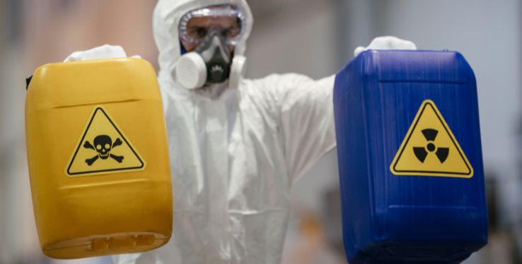 Man holding 2 hazardous chemicals bins